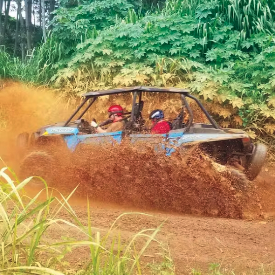 An ATV splashes in the mud on the Kauai Backroads ATV Adventure Tour